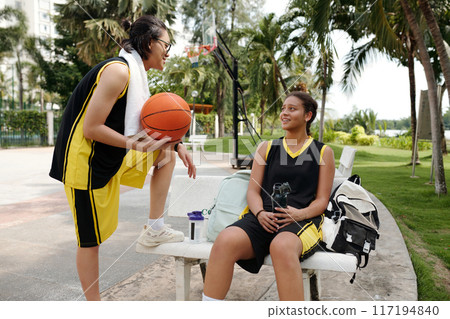 Two Girls Relaxing After Playing Basketball Outdoors Two Girls Relaxing After Playing Basketball Outdoors 117194840
