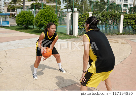 Playing Outdoor Basketball Game on Sports Court 117194850