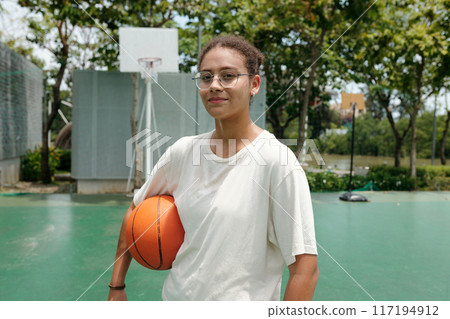 Portrait of Young Woman Holding Basketball Outdoors Portrait of Young Woman Holding Basketball Outdoors 117194912