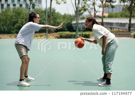 Playing Basketball Outdoors on Sunny Afternoon 117194977