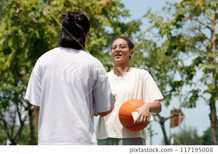 Playing Basketball Outdoors with Friends and Smiling Playing Basketball Outdoors with Friends and Smiling 117195008
