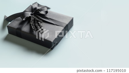 Black gift box with bow on blue background. Banner. Close up. Copy space. Present for Father Day, Birthday or Black Friday. Sale. 117195010