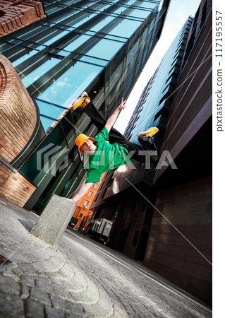 Urban breakdancing captured in action. Dancer flips dressed fit wear with colorful highlights, framed by geometric cityscape. Urban breakdancing captured in action. Dancer flips dressed fit wear with colorful highlights, framed by geometric cityscape. 117195557
