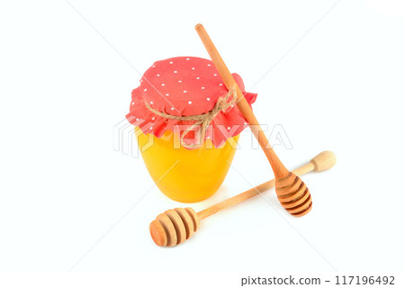 Honey pot and wooden drizzler isolated on white. 117196492