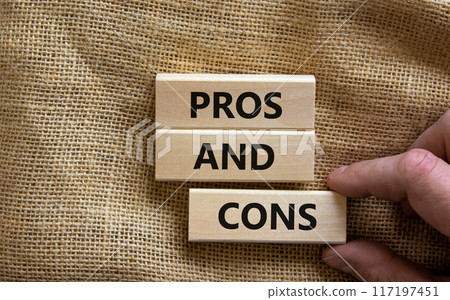 Pros and cons symbol. Wooden blocks with words 'Pros and cons'. Beautiful canvas background, businessman hand. Business, pros and cons concept, copy space. 117197451
