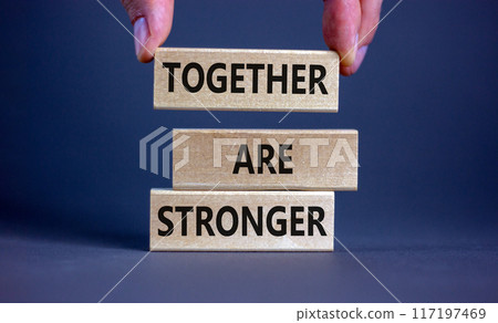 Together are stronger symbol. Concept words 'Together are stronger' on wooden blocks on a beautiful grey background. Businessman hand. Business, motivational and together are stronger concept. 117197469