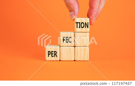 Perfection symbol. Concept word Perfection on beautiful wooden blocks. Businessman hand. Beautiful orange background. Business perfection concept. Copy space. 117197487