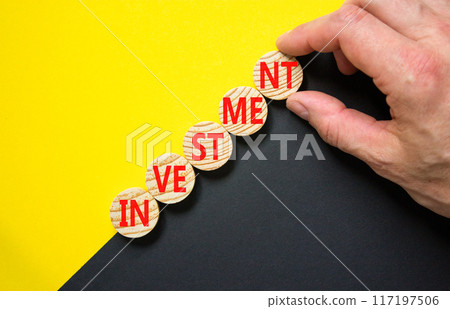 Investment symbol. Concept word Investment on beautiful wooden circles. Beautiful yellow and black background. Businessman hand. Business investment concept. Copy space. 117197506