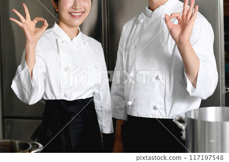 Smiling Asian man and woman in the food service industry working in the kitchen Smiling Asian man and woman in the food service industry working in the kitchen 117197548