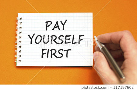 Pay yourself first symbol. Concept words Pay yourself first on beautiful white note. Beautiful orange background. Businessman hand. Business and pay yourself first concept. Copy space. Pay yourself first symbol. Concept words Pay yourself first on beautiful white note. Beautiful orange background. Businessman hand. Business and pay yourself first concept. Copy space. 117197602