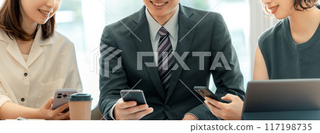 三位日本商人,男性和女性,使用智慧型手機交談 三位日本商人,男性和女性,使用智慧型手機交談 117198735