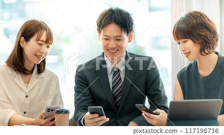 三位日本商人，男性和女性，使用智慧型手機交談 117198736