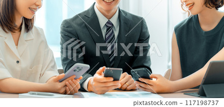 三位日本商人，男性和女性，使用智慧型手機交談 117198737