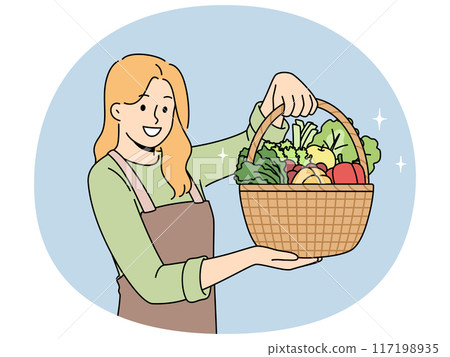 Woman farmer with basket full of vegetables recommends eating natural organic food 117198935