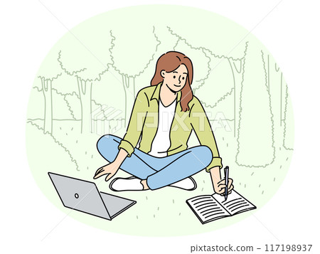 Woman student is sitting on lawn making notes in notebook and using laptop enjoying working in park 117198937