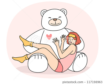 Giant teddy bear near sitting teenage girl in pajamas and sleep mask rejoicing at cute present Giant teddy bear near sitting teenage girl in pajamas and sleep mask rejoicing at cute present 117198963