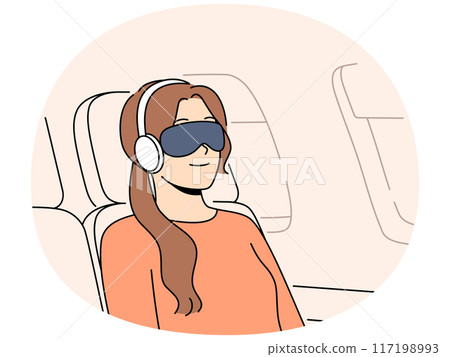 Young woman passenger flight with blindfold and earphones sleeps in airplane chair Young woman passenger flight with blindfold and earphones sleeps in airplane chair 117198993