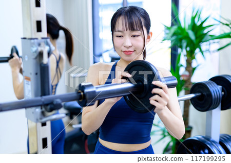 女性在健身房訓練身體、槓鈴板、重量選擇、肌肉訓練女性、鍛煉 女性在健身房訓練身體、槓鈴板、重量選擇、肌肉訓練女性、鍛煉 117199295