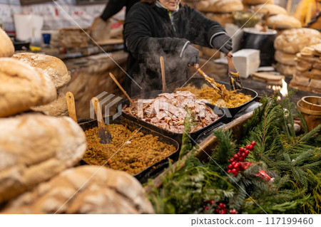 Christmas street food festival on fair in town center, winter holidays. BBQ street food for sale. Concept of shopping, holidays and happiness Christmas fair. High quality photo Christmas street food festival on fair in town center, winter holidays. BBQ street food for sale. Concept of shopping, holidays and happiness Christmas fair. High quality photo 117199460