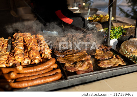 Christmas street food festival on fair in town center, winter holidays. BBQ street food for sale. Concept of shopping, holidays and happiness Christmas fair. High quality photo Christmas street food festival on fair in town center, winter holidays. BBQ street food for sale. Concept of shopping, holidays and happiness Christmas fair. High quality photo 117199462