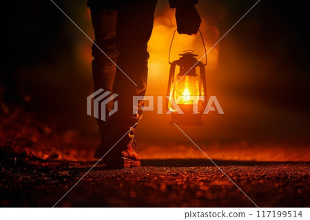 legs of a man with a lantern on a dark road legs of a man with a lantern on a dark road 117199514