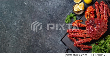 Vibrant king crab and assorted lemon slices arranged on a dark, rustic slate surface, cilantro, dark textured background, copy space, top view Vibrant king crab and assorted lemon slices arranged on a dark, rustic slate surface, cilantro, dark textured background, copy space, top view 117200579