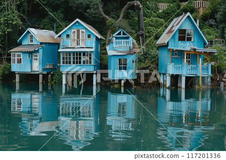 blue houses on pillars on a lake blue houses on pillars on a lake 117201336
