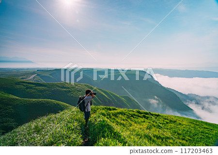 Climber looking at the view from the summit 117203463