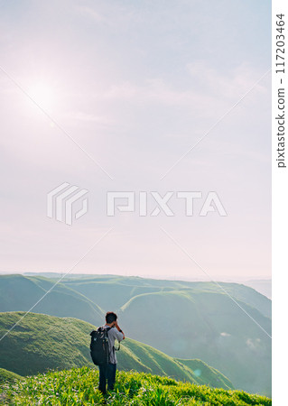 Climber looking at the view from the summit Climber looking at the view from the summit 117203464