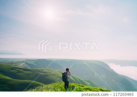 Climber looking at the view from the summit Climber looking at the view from the summit 117203465