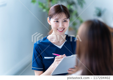 Female staff providing counseling at a beauty clinic 117204402