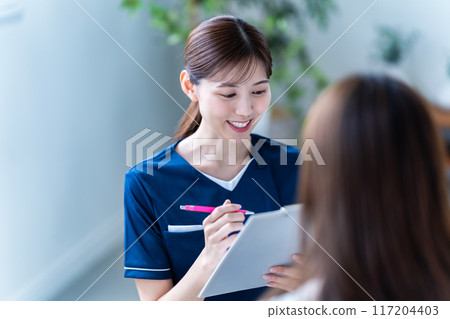 Female staff providing counseling at a beauty clinic 117204403