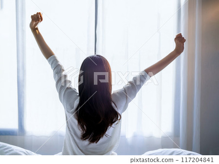 Image of a woman waking up in the morning and a refreshing room 117204841