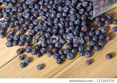 Juicy fresh blueberries on wooden table 117205570