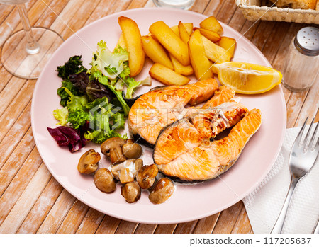Delicious grilled salmon fillet with garnish of potatoes and mushrooms Delicious grilled salmon fillet with garnish of potatoes and mushrooms 117205637