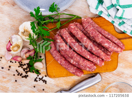 Catalan raw pork sausage longaniza ready for grilling on wooden board Catalan raw pork sausage longaniza ready for grilling on wooden board 117205638
