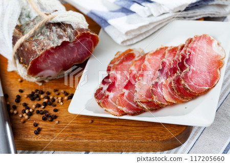 Smoked pork tenderloin sliced on wooden cutting board 117205660