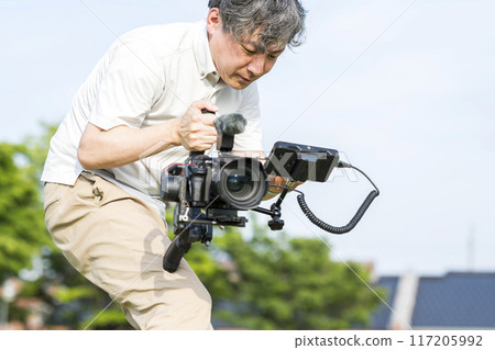Man shooting video using gimbal | SLR | Movie shooting image | TV shooting image | Advertising shooting image Man shooting video using gimbal | SLR | Movie shooting image | TV shooting image | Advertising shooting image 117205992