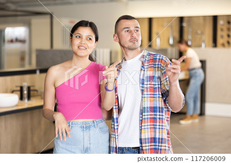 Husband and wife choosing bathroom accessories together at hardware store Husband and wife choosing bathroom accessories together at hardware store 117206009