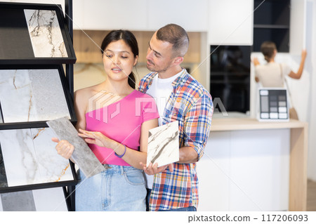 Husband and wife discussing the color of ceramic tiles for the bathroom in hardware store Husband and wife discussing the color of ceramic tiles for the bathroom in hardware store 117206093