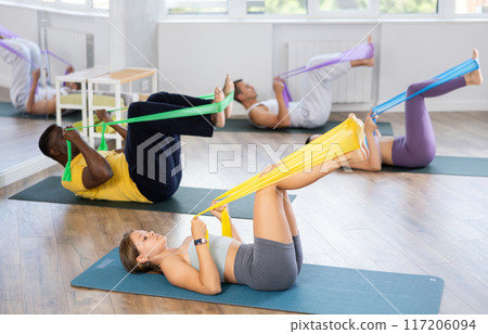 Fit girl exercising with resistance band in pilates class Fit girl exercising with resistance band in pilates class 117206094