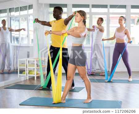 Group of athletes train in Pilates class using elastic bands Group of athletes train in Pilates class using elastic bands 117206206