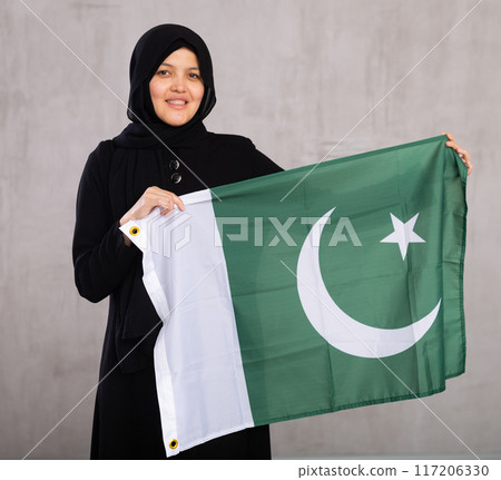 Young woman in hijab posing with Pakistan flag 117206330