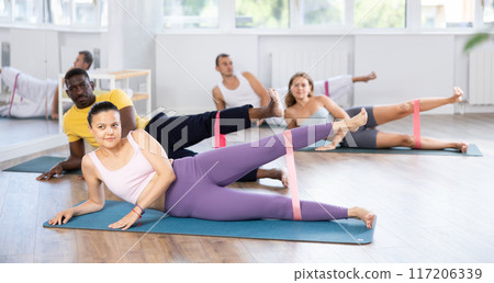 Asian woman exercising with resistance loop band in fitness class Asian woman exercising with resistance loop band in fitness class 117206339