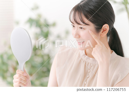 A woman smiling with a mirror A woman smiling with a mirror 117206755