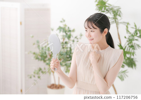 A woman smiling with a mirror A woman smiling with a mirror 117206756