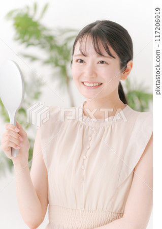 A woman smiling with a mirror 117206919