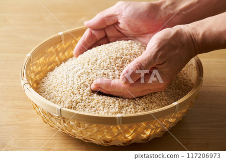 用手將發芽的米舀入漏勺中。 117206973