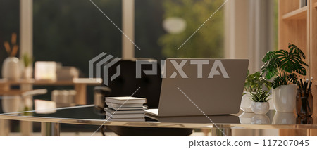 A back view image of a laptop computer on a modern office desk in a contemporary office room. 117207045