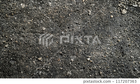 A detailed view of the texture of black asphalt surface 117207363